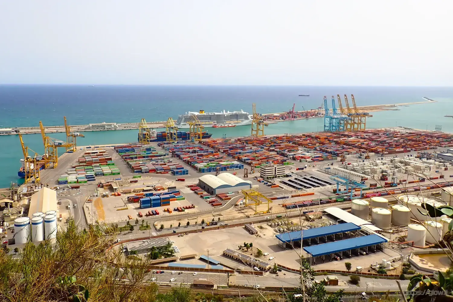 Picture of the Port of Barcelona with lots of containers and a large cruise ship